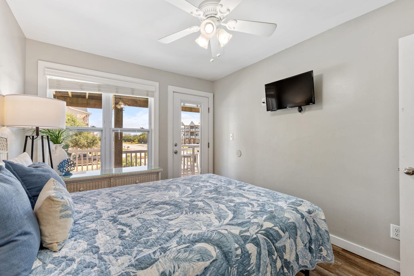 Bedroom with tropical leaf bedding and deck door