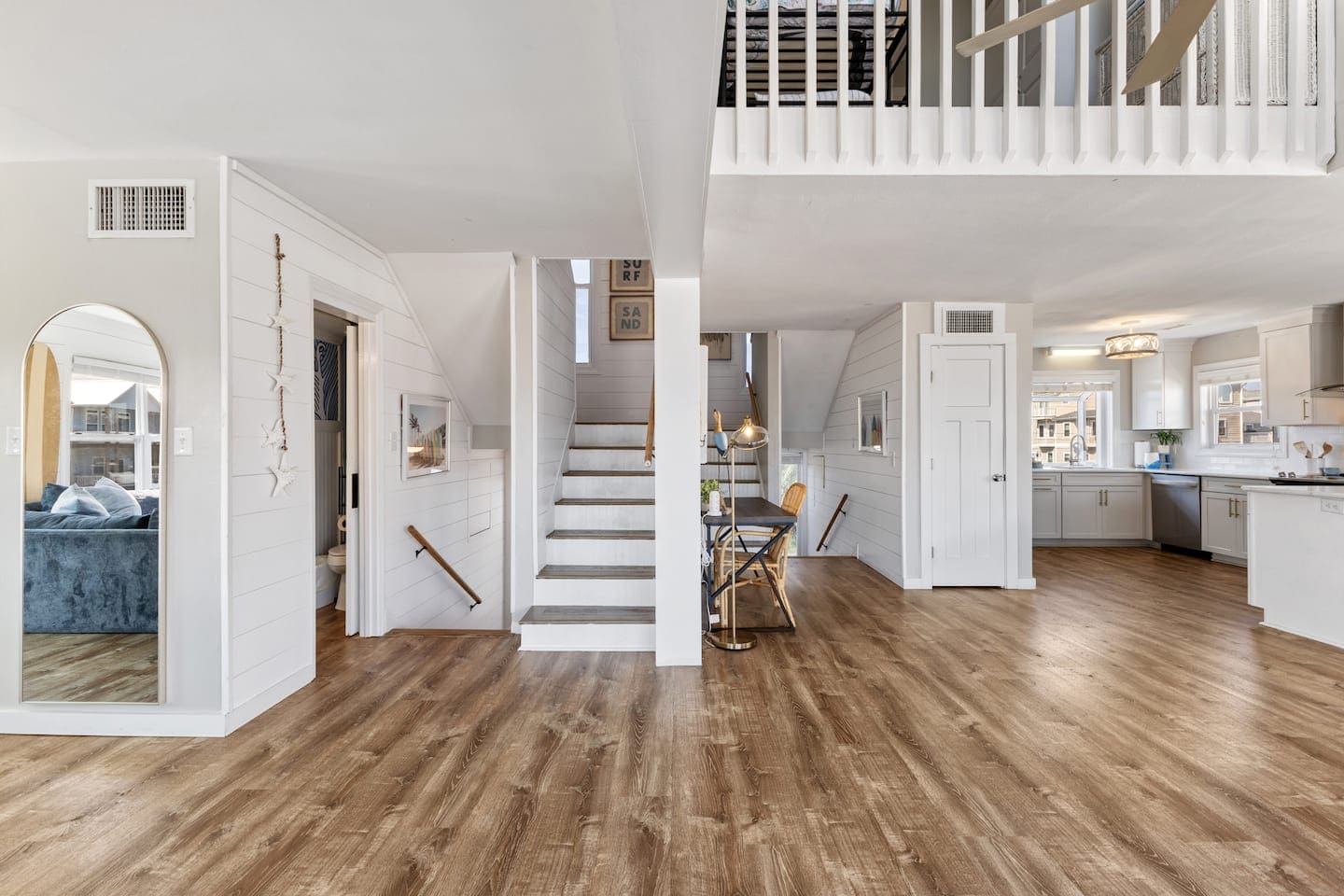 Entry stairs, loft railing, and open kitchen beyond