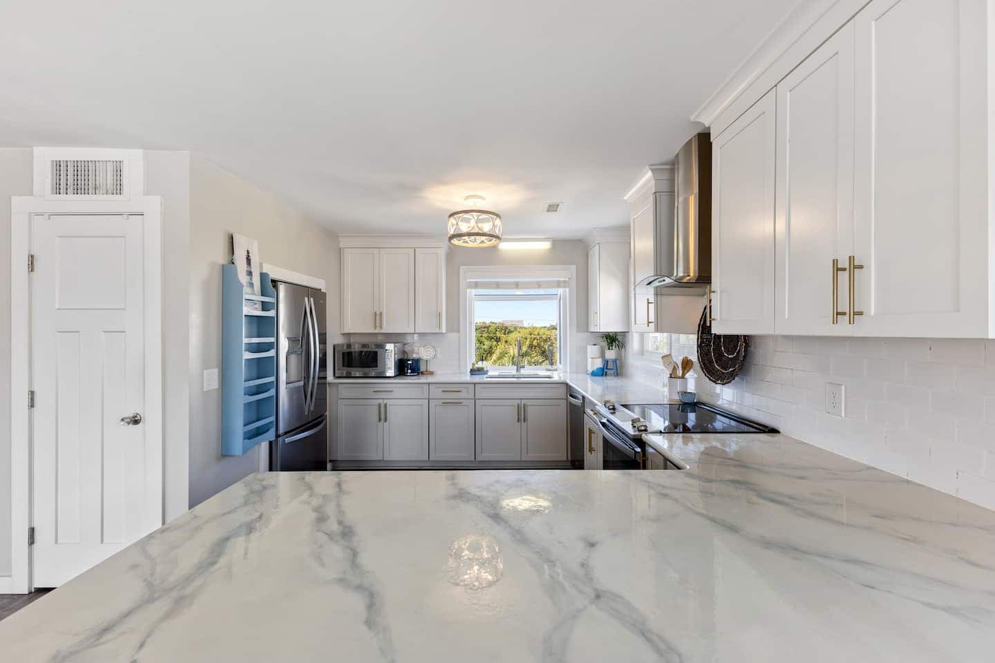 Kitchen peninsula with marble counters and gold hardware