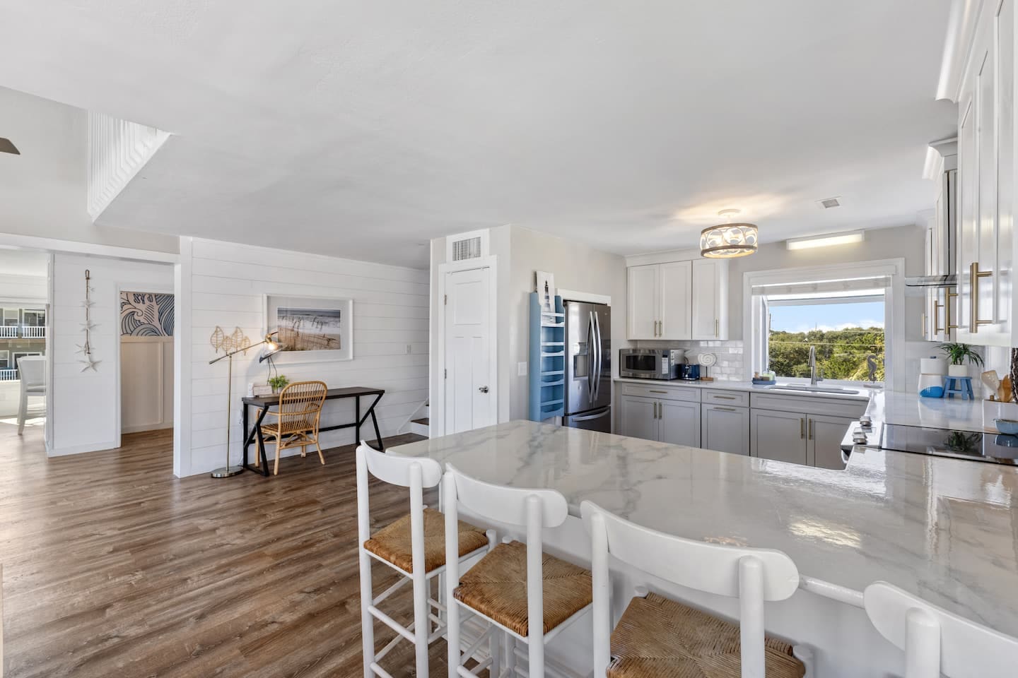 Kitchen island with rattan stools and workspace nook