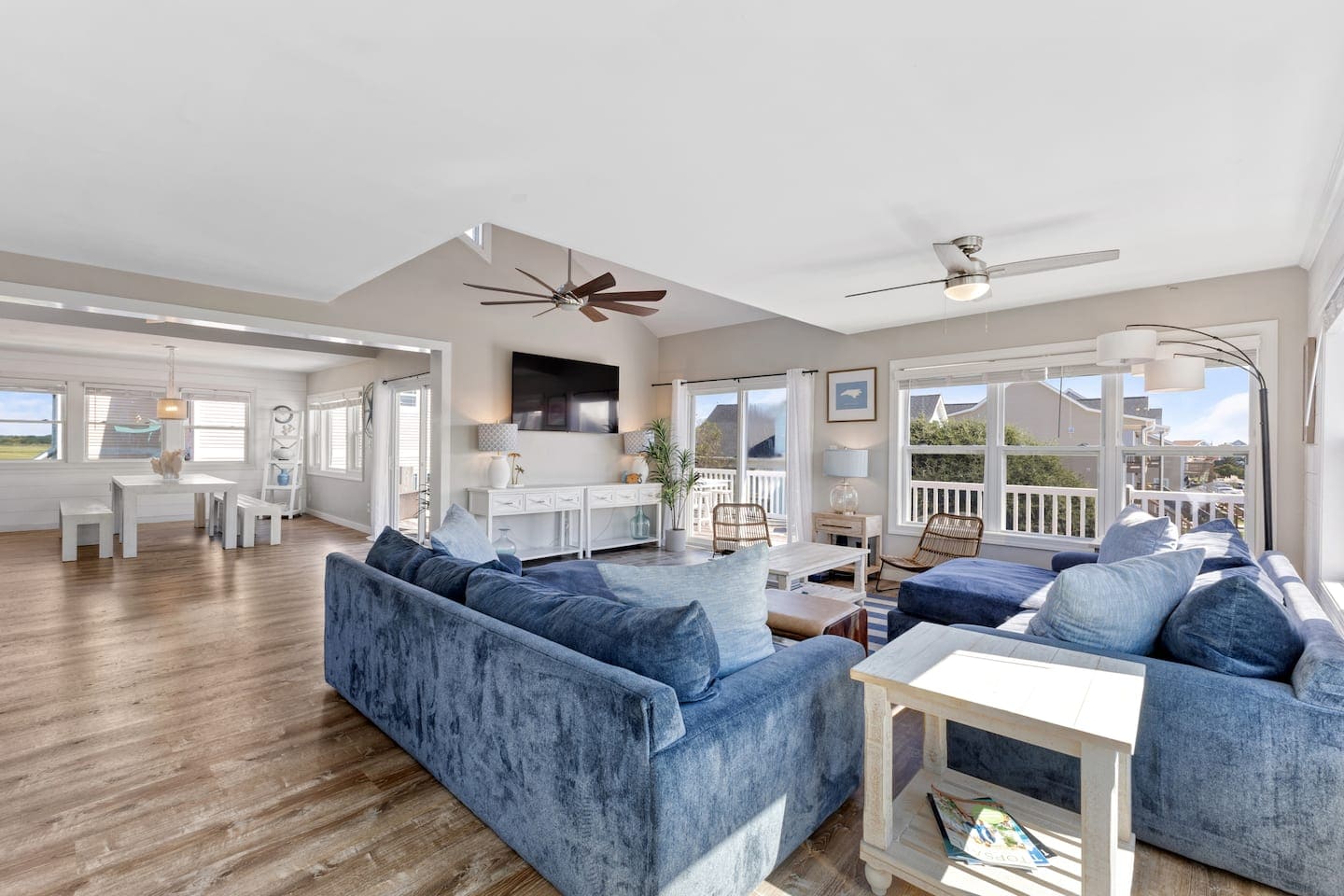 Living and dining area with vaulted ceilings and indigo sofa