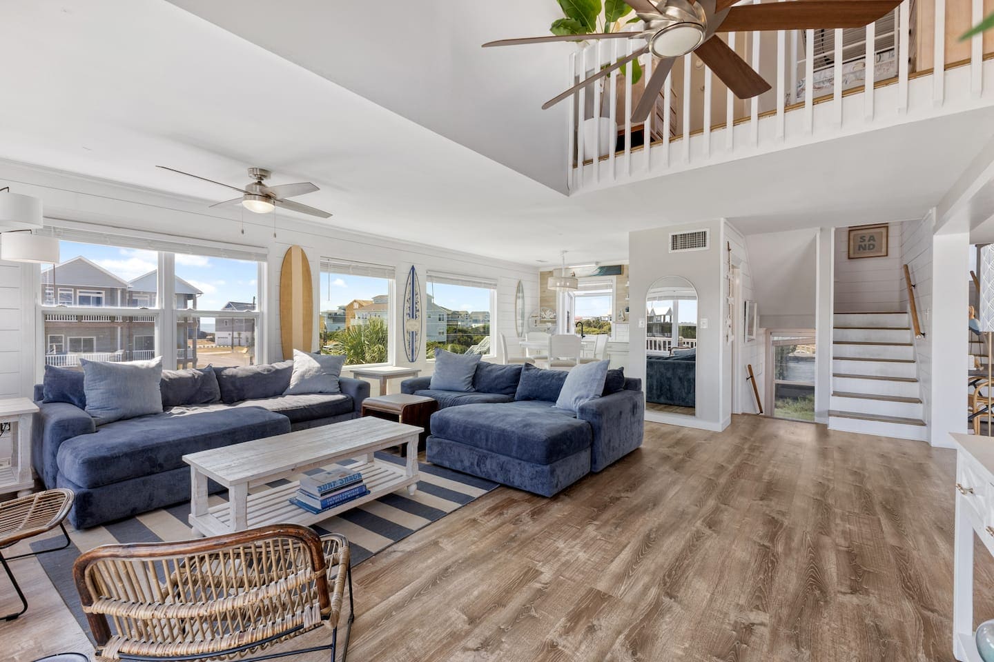 Navy sectional, loft railing, and coastal living space