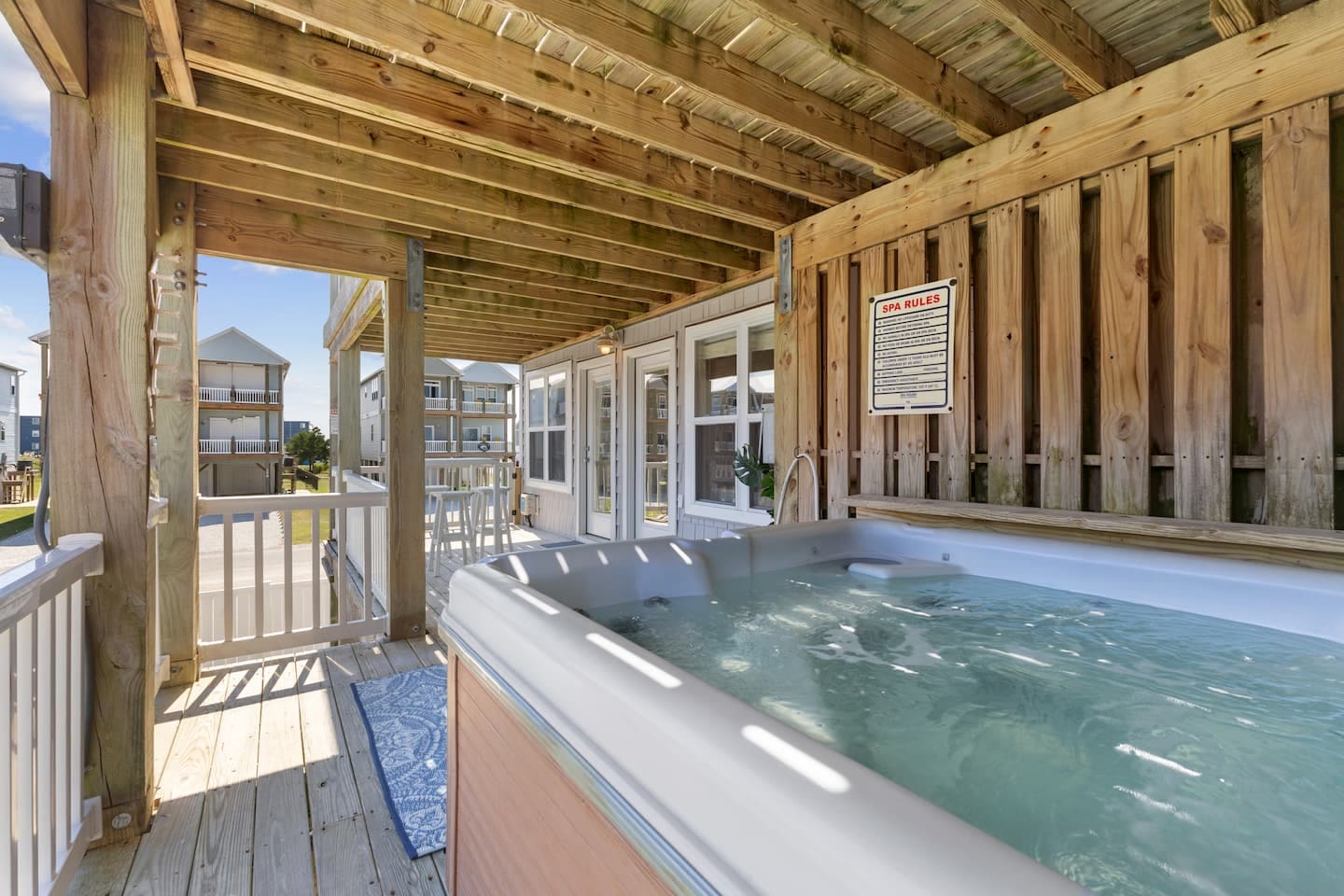 Covered deck hot tub with spa rules and neighborhood view