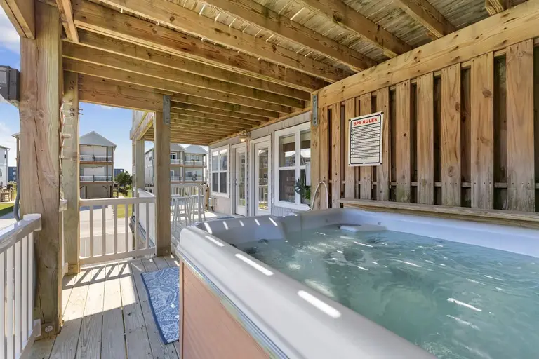 Covered deck hot tub at Topsail Paradise, one of two hot tubs on the property